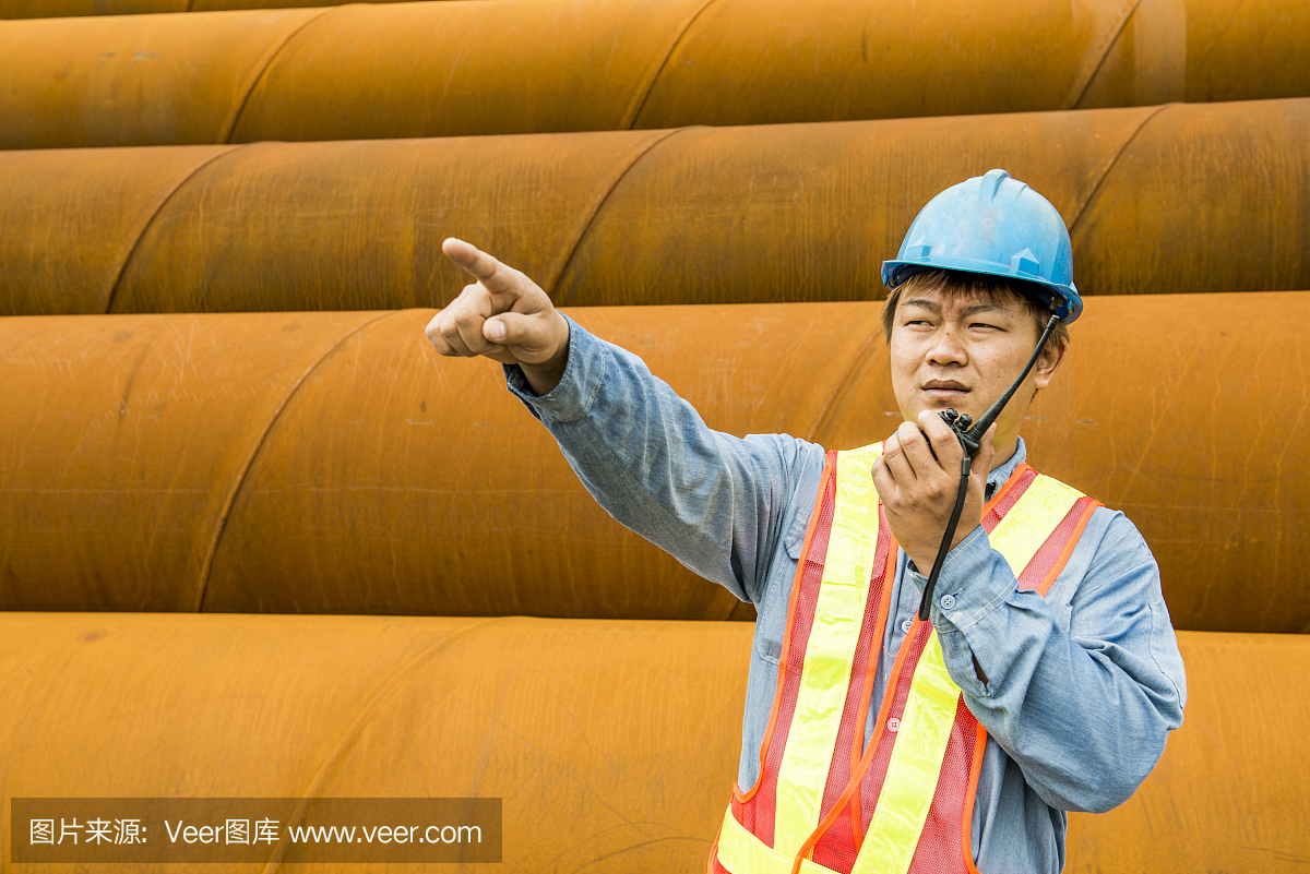 建筑工人在起重機(jī)的背景下檢查現(xiàn)場